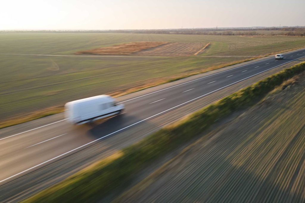 Fourgon blanc en transport express sur autoroute, livraison urgente depuis Montélimar vers la France et l'Europe – Fast Express
